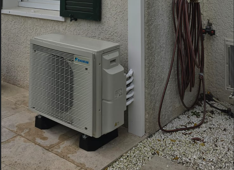 Groupe extérieur Daikin posé sur plots antivibratiles en façade d'une maison à Gif-sur-Yvette, Essonne
