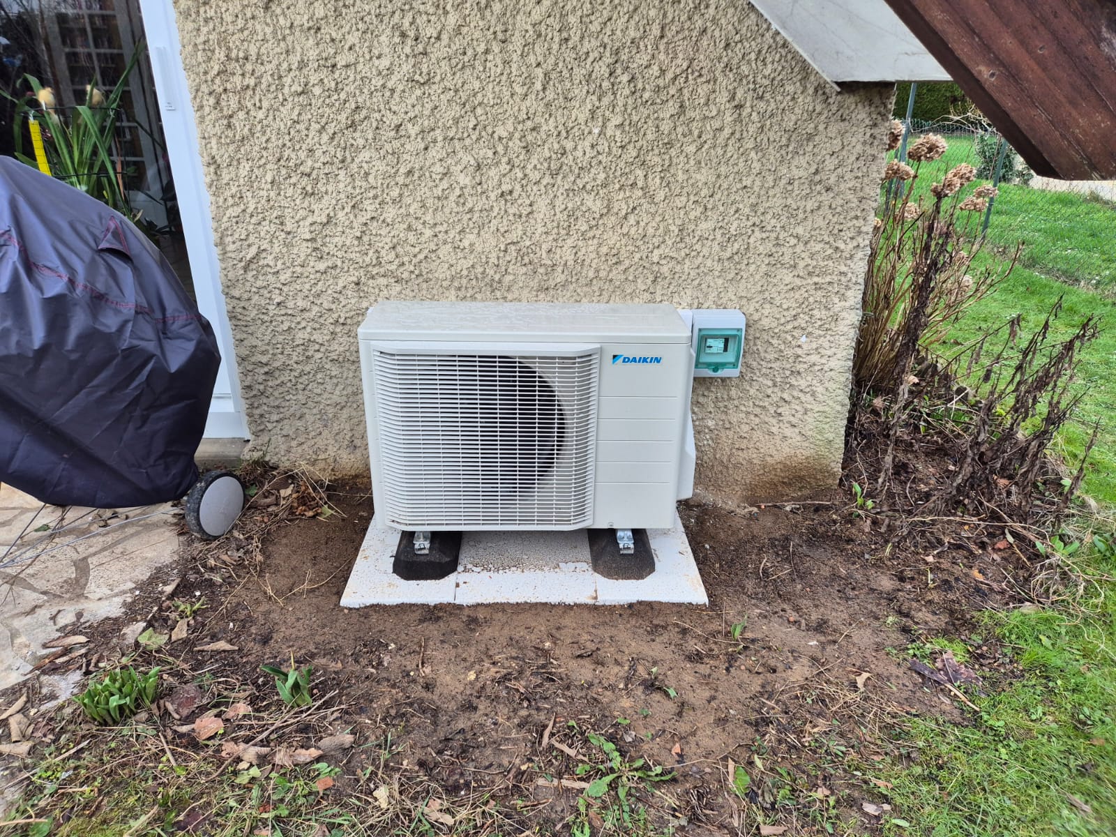 Groupe extérieur Daikin RXM50A8 posé sur dalle béton avec coffret électrique mural vert – PAC réversible Montigny-le-Bretonneux Saint-Quentin-en-Yvelines