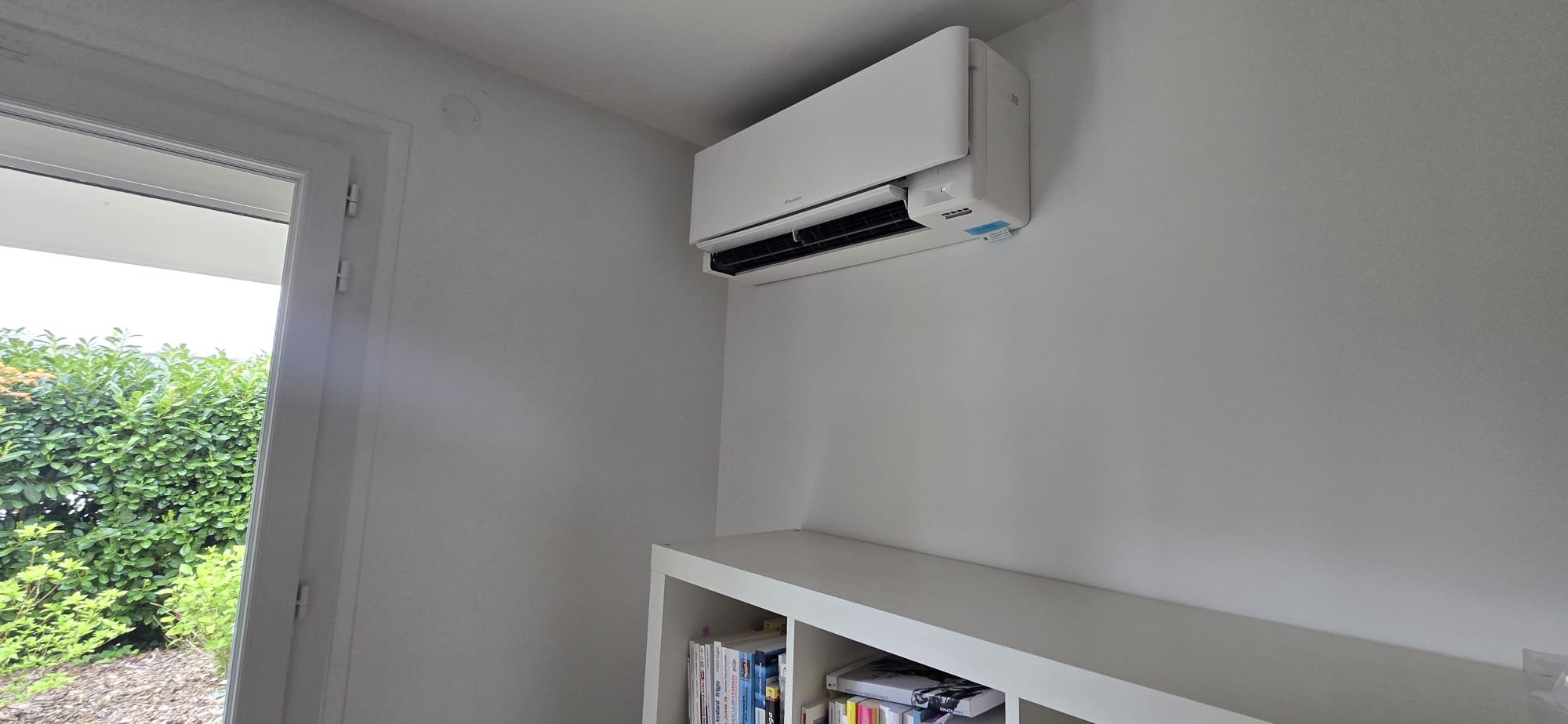 Unité murale Daikin Stylish au-dessus d'une bibliothèque dans un bureau à Gif-sur-Yvette