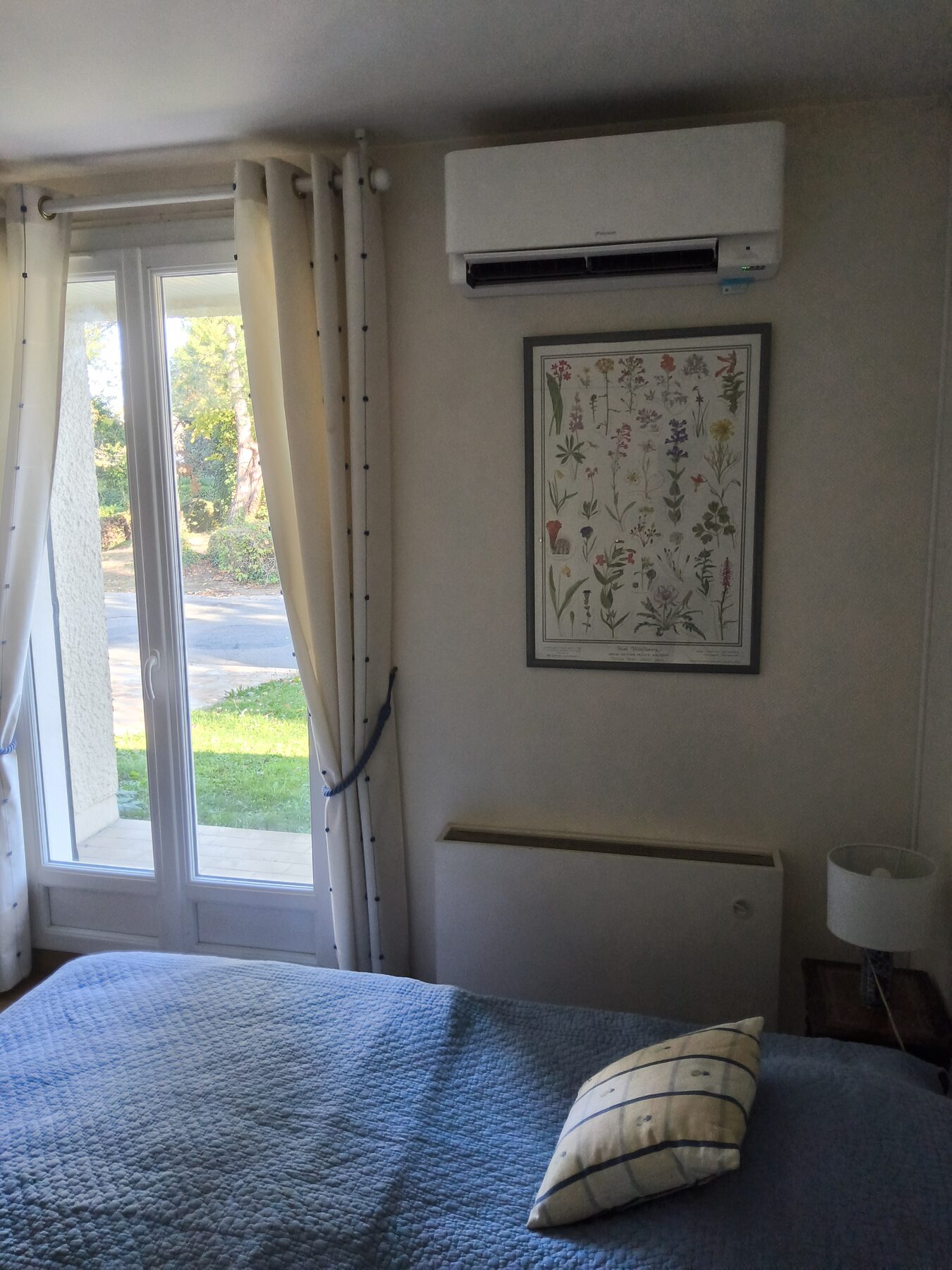 Unité murale Daikin Stylish en chambre, en chauffage réversible au-dessus de l'ancien radiateur électrique, à Saclay
