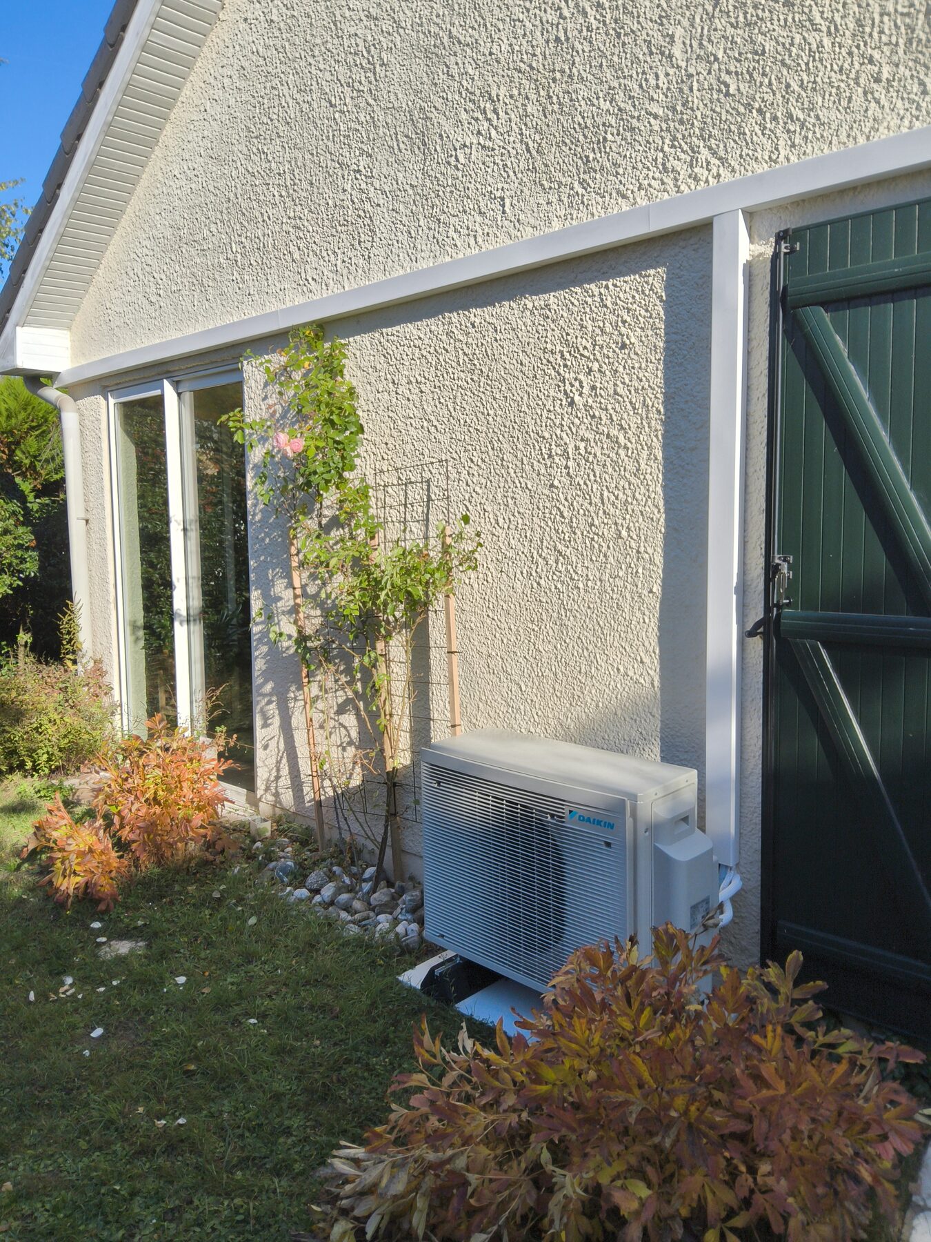 Groupe extérieur Daikin et liaisons frigorifiques dissimulées dans des goulottes blanches le long de l'avant-toit, à Saclay